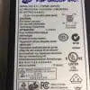 Power adapter label with safety and regulatory information.