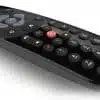 Black modern TV remote control on white background.