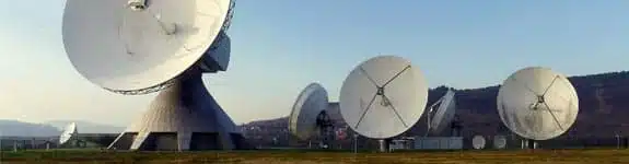 Satelitarne anteny telekomunikacyjne na polu.